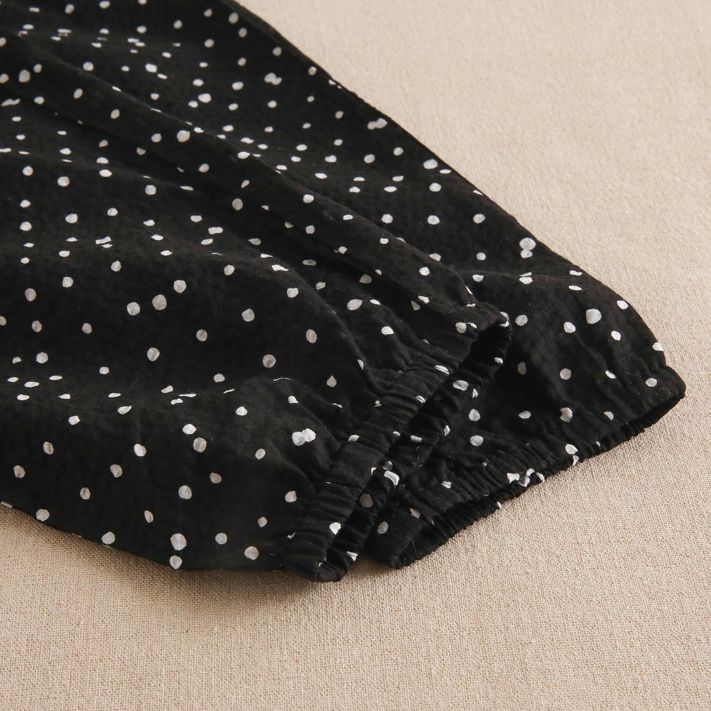Girls' black jumpsuit with white polka dots