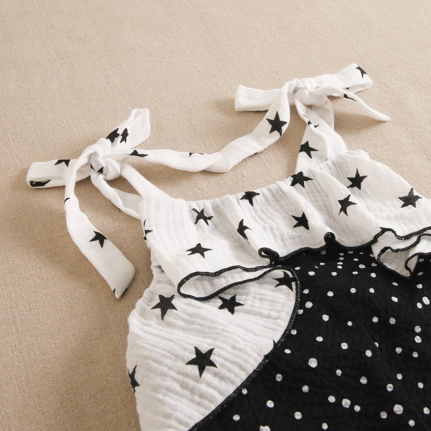 Girls' black jumpsuit with white polka dots