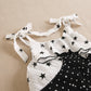 Girls' black jumpsuit with white polka dots